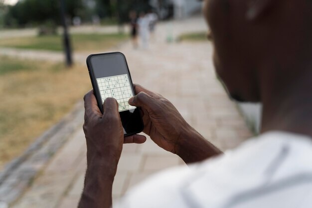 Personne jouant à un jeu de sudoku sur un smartphone