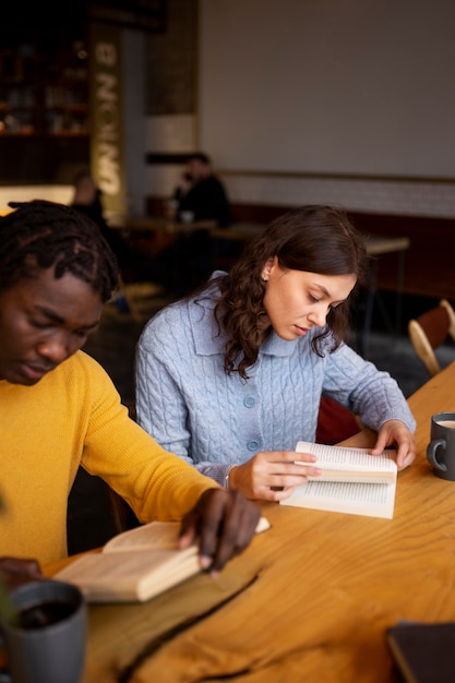 Photo gratuite personne lisant un livre dans un café