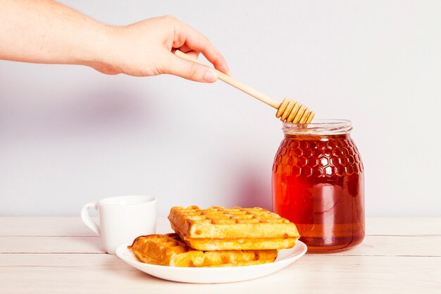 Photo gratuite personne, main, à, louche, cueillette, miel, pot, petit-déjeuner