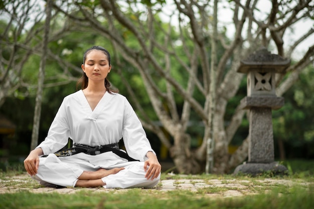 Photo gratuite personne méditant avant l'entraînement de taekwondo