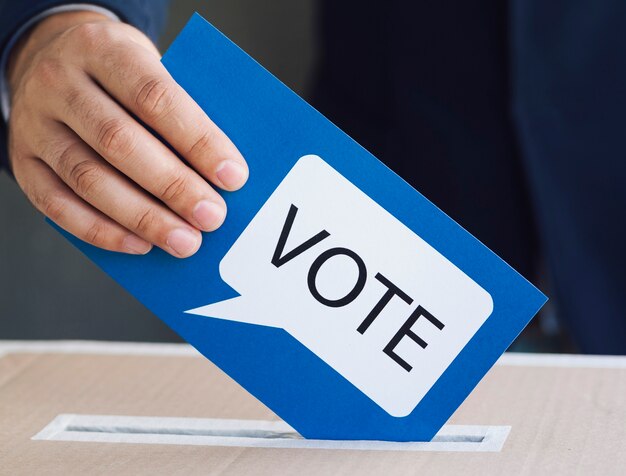 Personne mettant un bulletin de vote dans un bureau de vote