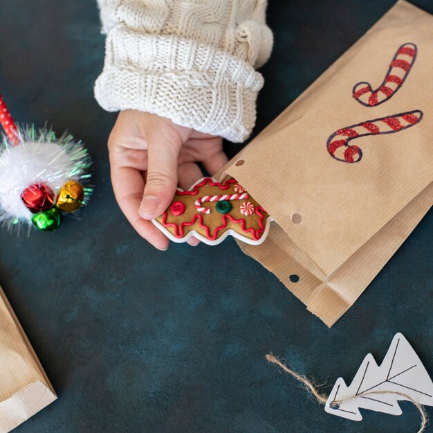 Personne mettant la friandise à l'intérieur du sac-cadeau de Noël décoré de canne