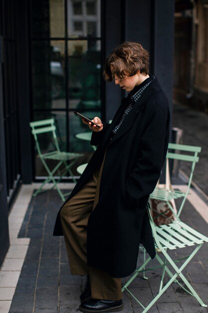 Personne non binaire regardant le téléphone