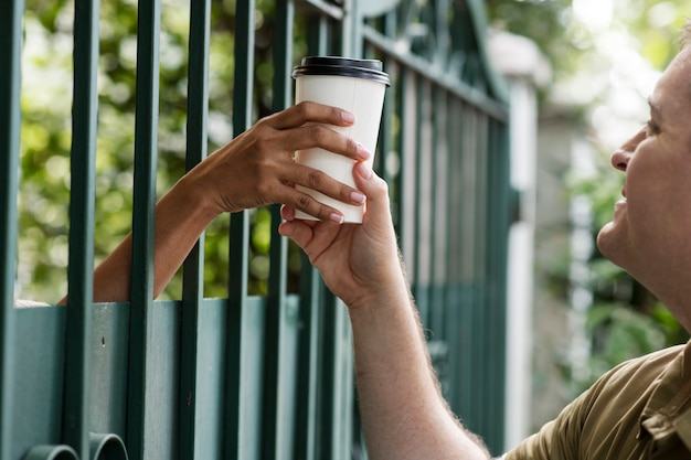 Photo gratuite personne partageant un café avec un voisin