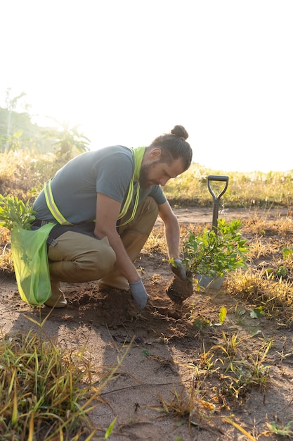 Personne plantant un arbre à la campagne