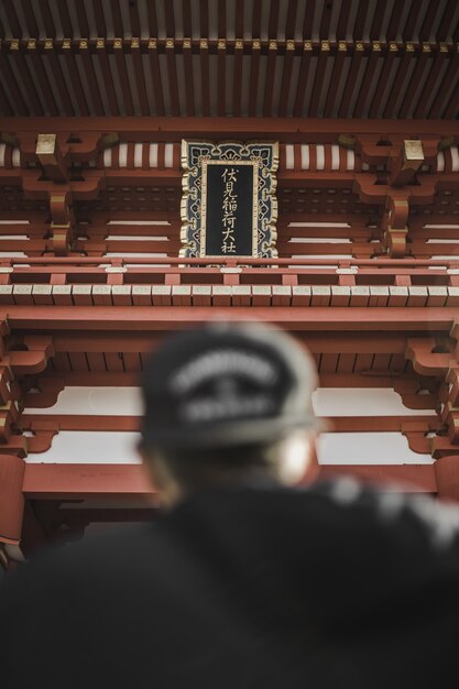 Personne portant une casquette noire en face de la tour