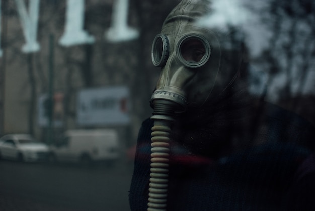 Photo gratuite personne portant un respirateur debout derrière la vitre