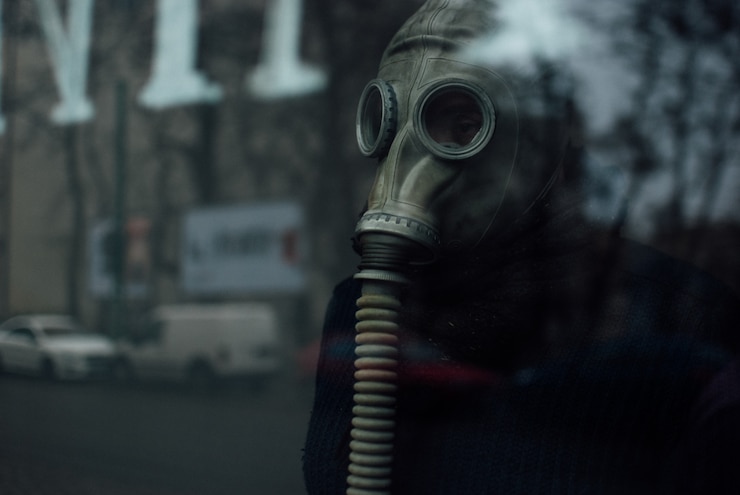Photo gratuit personne portant un respirateur debout derrière la vitre
