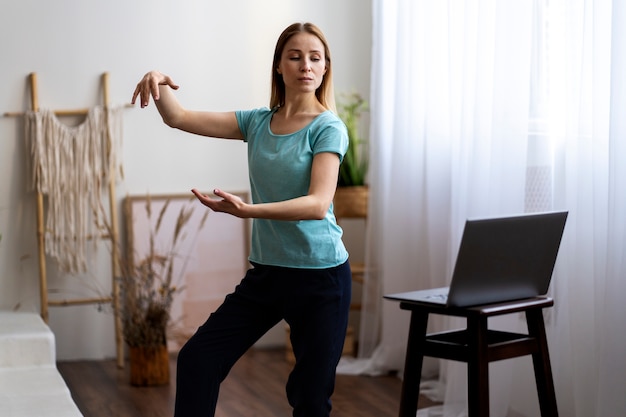 Photo gratuite personne pratiquant le tai-chi à l'intérieur