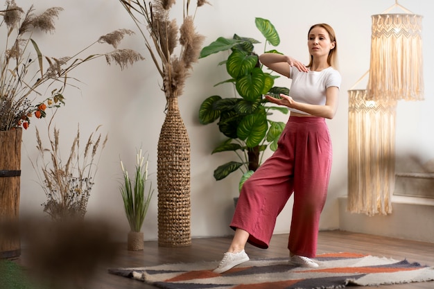 Photo gratuite personne pratiquant le tai-chi à l'intérieur