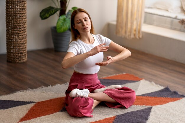 Photo gratuite personne pratiquant le tai-chi à l'intérieur