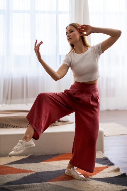 Photo gratuite personne pratiquant le tai-chi à l'intérieur