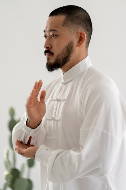 Photo gratuite personne pratiquant le tai-chi à l'intérieur