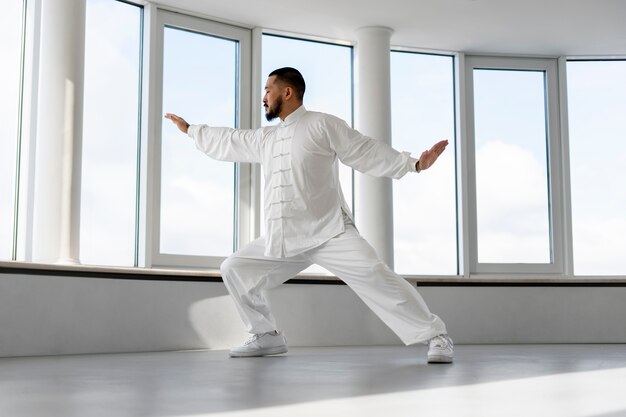 Personne pratiquant le tai-chi à l'intérieur