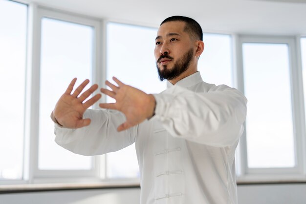 Personne pratiquant le tai-chi à l'intérieur