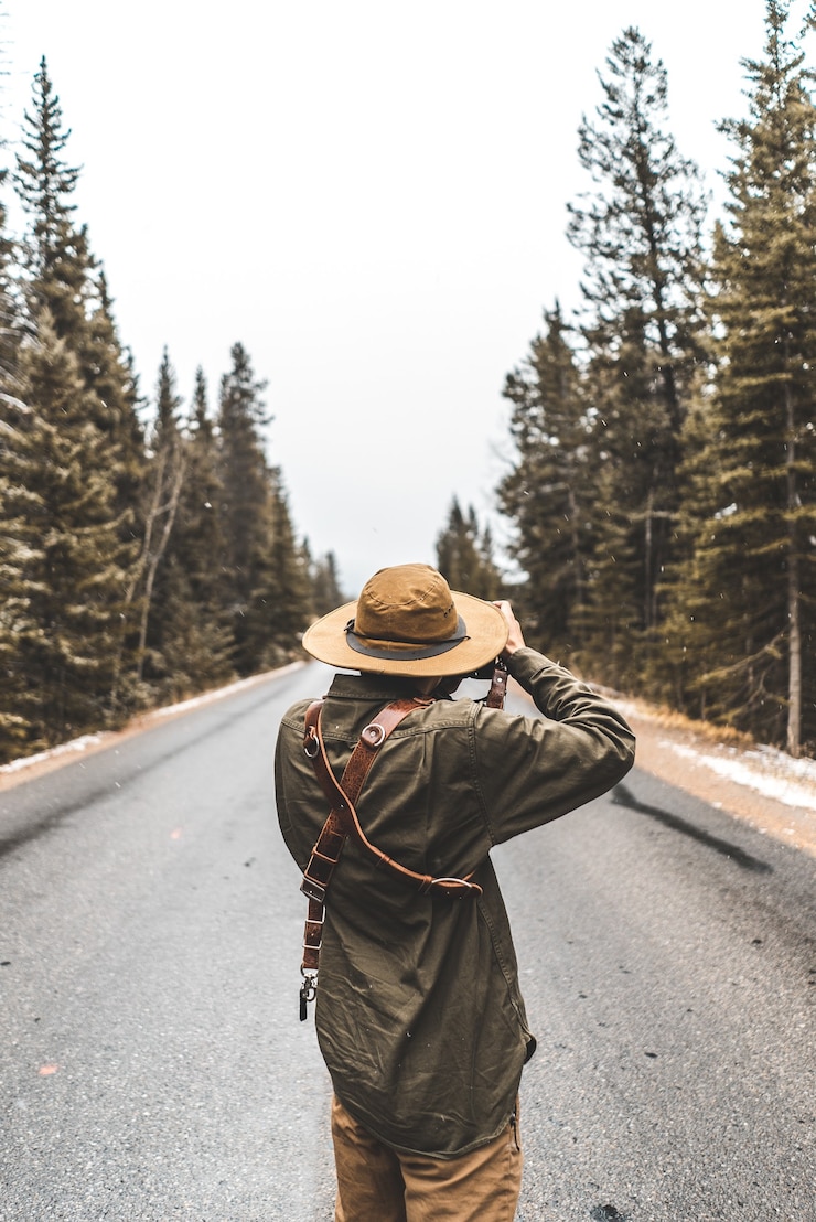 Photo gratuit personne prenant une photo de route entre les arbres