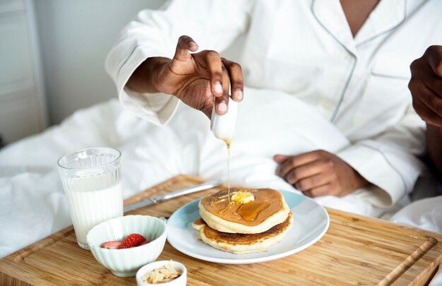 Une personne prenant son petit déjeuner au lit