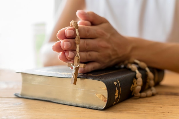 Personne priant avec chapelet et livre sacré