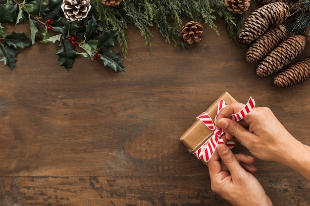 Personne qui attache un arc sur une boîte cadeau