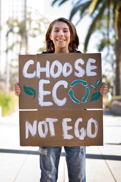 Photo gratuite personne qui proteste avec une pancarte pour la journée mondiale de l'environnement à l'extérieur