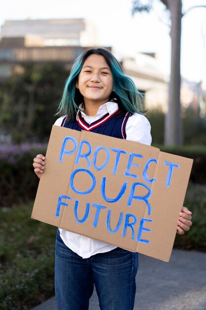 Personne qui proteste avec une pancarte pour la journée mondiale de l'environnement à l'extérieur