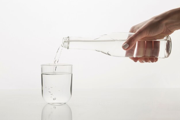 Personne qui verse de l'eau en vue de face en verre