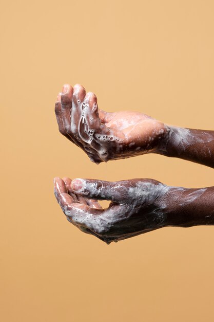 Personne se lavant les mains avec du savon isolé sur orange