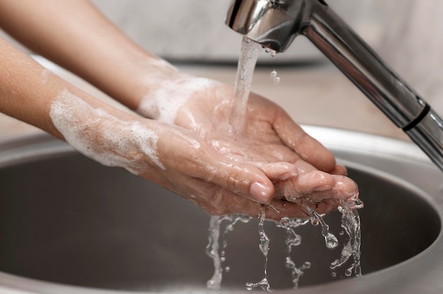 Personne se laver les mains dans un évier close-up