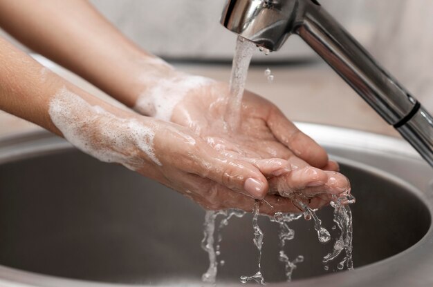 Personne se laver les mains dans un évier close-up