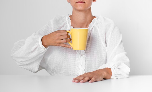 Photo gratuite personne sérieux vue de face tenant une tasse