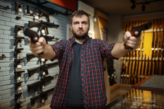 Personne de sexe masculin achetant un pistolet pour la sécurité dans un magasin d'armes autodéfense et passe-temps de tir sportif