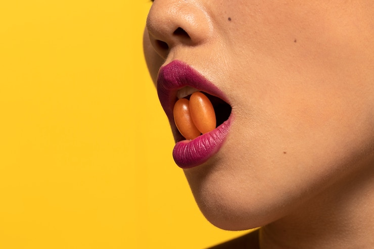 Photo gratuit personne tenant des bonbons de jelly bean dans sa bouche