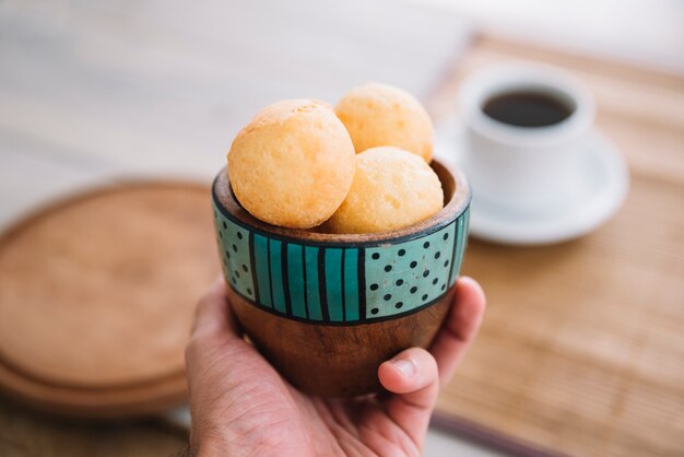 Personne tenant des boulettes de fromage dans un bol