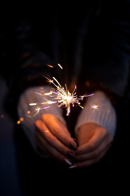 Personne tenant un cierge magique festif