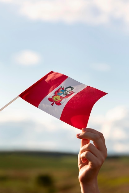 Personne tenant le drapeau du Pérou à l'extérieur