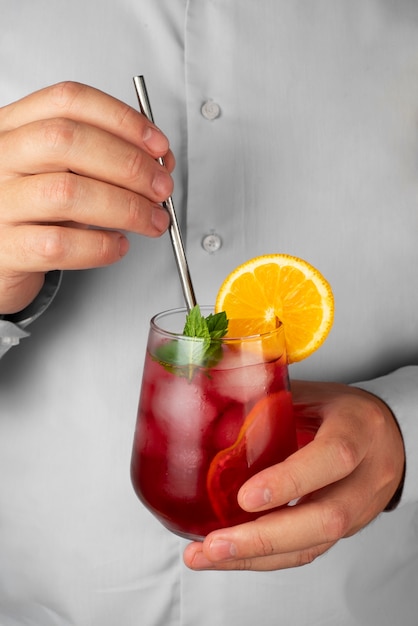 Photo gratuite personne tenant du thé glacé à l'hibiscus dans un récipient en verre transparent