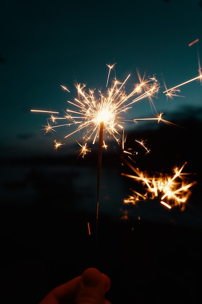 Photo gratuite personne tenant des feux de bengale ou des cierges magiques