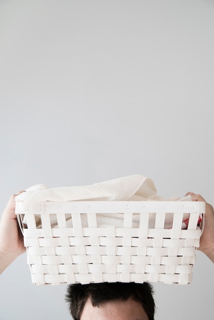 Photo gratuite personne tenant un panier à linge sur la tête