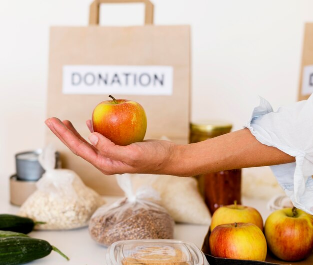 Personne tenant la pomme pour un don de charité