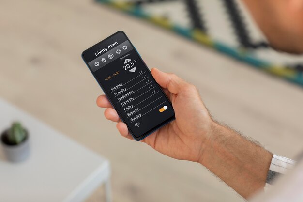 Personne tenant un smartphone avec une application domotique