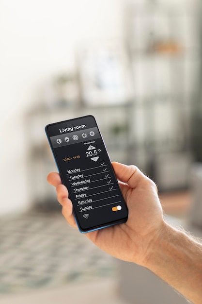 Personne tenant un smartphone avec une application domotique