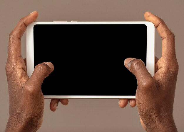 Personne tenant une tablette numérique en position horizontale