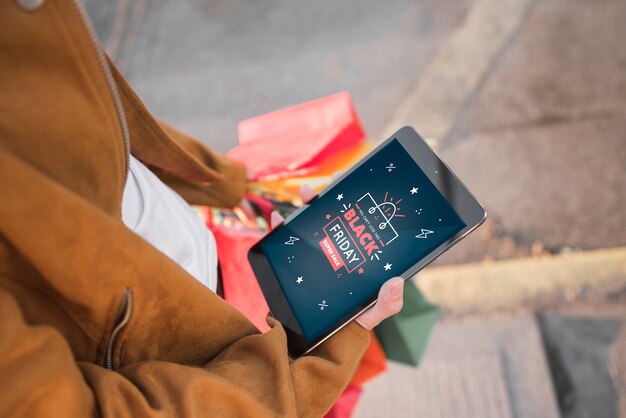 Personne tenant une tablette avec la recherche du vendredi noir