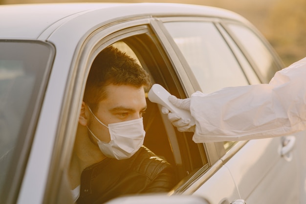 Personne en tenue de protection vérifie la température