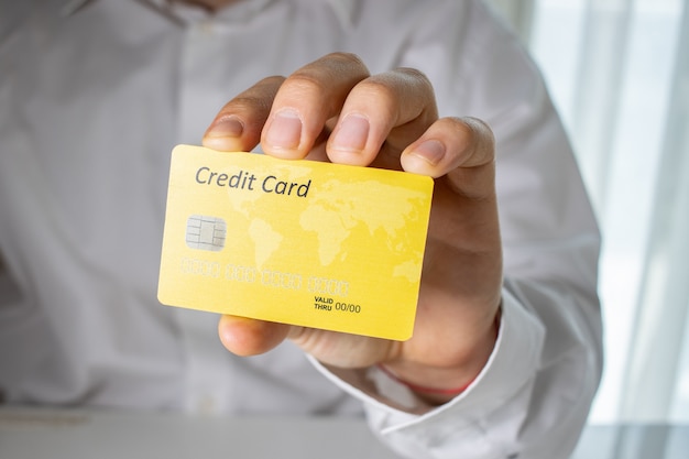 Photo gratuite personne titulaire d'une carte de crédit jaune