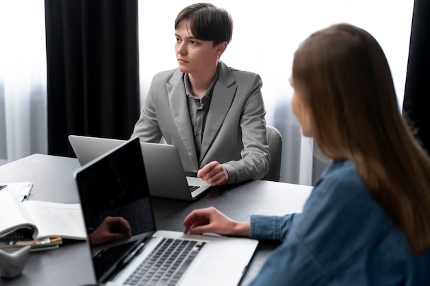 Personne trans travaillant au bureau avec des collègues