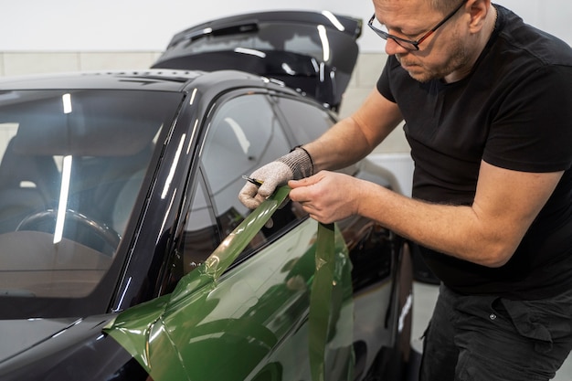 Personne travaillant sur l'habillage de voiture