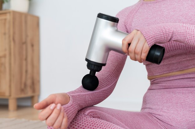 Personne utilisant un pistolet de massage