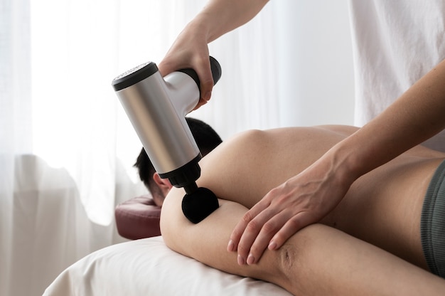 Personne utilisant un pistolet de massage