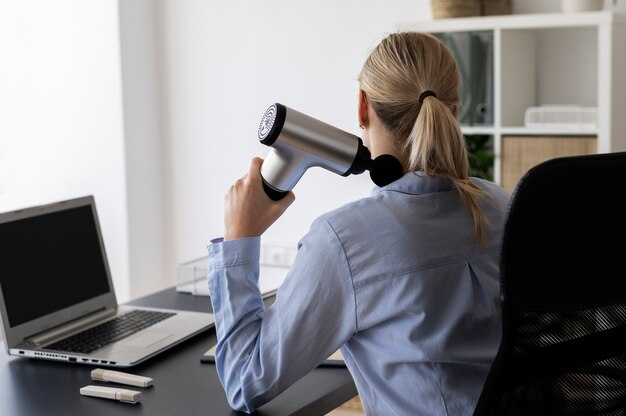 Personne utilisant un pistolet de massage